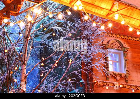 decorations - beautiful wooden house, lighting, snow on birchs Stock Photo