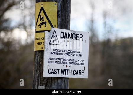 ELECTRICITY DANGER OF DEATH WARNING SIGN ON POLE RE FISHERMEN CHILDREN WARNINGS FISHING RODS CASTING WITH CARE SIGNS ETC UK Stock Photo