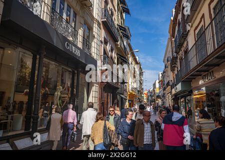 Seville, Spain - October 25, 2023 - People at Calle Sierpes promenade lined with shops, bustling pedestrianised shopping street, commercial heart of t Stock Photo
