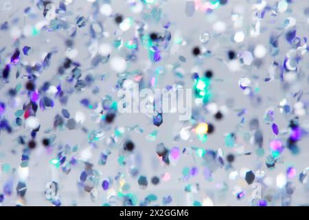 many falling multi-colored sequins on gray background, purple and green Stock Photo