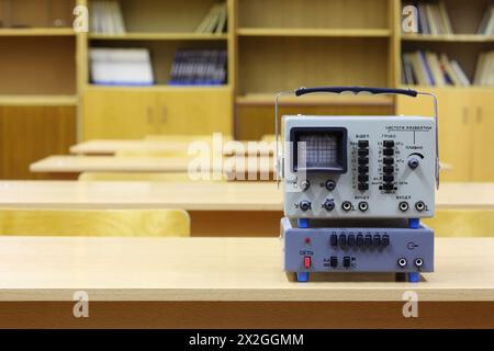 Old educational oscilloscope on desk in empty physics school class Stock Photo
