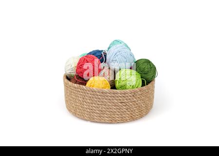 Clews or Skeins of colorful threads in a jute rope basket, isolated on white Stock Photo