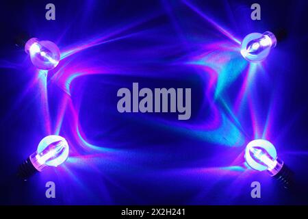 Four lamps illuminated brightly on deep blue background; rectangular Stock Photo