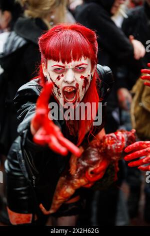 MOSCOW - MAY 14: Unidentified red-haired screaming made-up female participant with bloody face and with dead bloody baby-doll in her arms at Zombie Wa Stock Photo