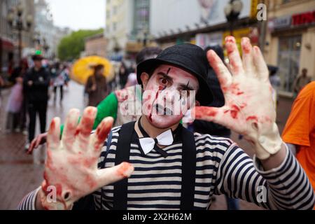 MOSCOW - MAY 14: Unidentified made-up participant - clown-murderer in a striped shirt with bow-tie, in bowler and gloves - at Zombie Parade on Old Arb Stock Photo
