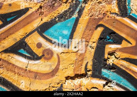 Detail of ocher and turquoise colors graffiti painted on the wall of a ruin, photogaphed in Portugal Stock Photo