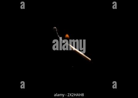 Lit and falling match on a black background. Stock Photo