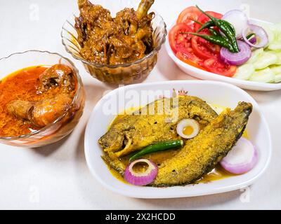 Bengali Indian non-vegetarian cuisines consisting of parse fish chicken masala and prawn curry food dishes. Stock Photo