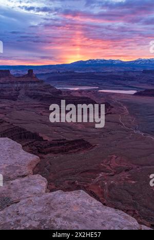 A sun pillar light up the sky at sunrise behind the La Sal Mountains, seen from Dead Horse Point viewpoint, near Moab, Utah. Stock Photo