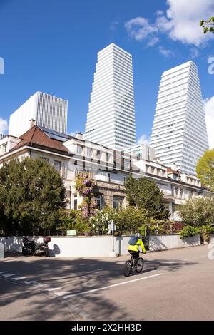 Basel, Switzerland - April 18, 2024: Beautiful old residential houses area in Schaffhauserrheinweg and tall modern Roche Towers behind it, and a cycli Stock Photo