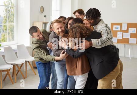 Diverse Group of People Embracing at Office Stock Photo