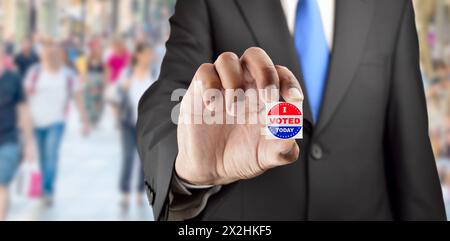 Man holding vote button on blue background for the elections in the United States Stock Photo