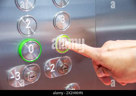 Cropped shot of a man pressing a button in an elevator Stock Photo