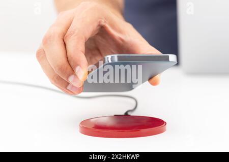 Man charging smartphone using wireless pad at home Stock Photo
