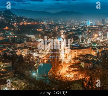 The picturesque cityscape of Sarajevo bathed in the soft glow of twilight invites travelers to explore its historic landmarks and immerse themselves i Stock Photo