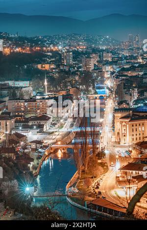 As evening descends, the city's skyline glows with a warm hue, painting a mesmerizing picture against the backdrop of the Miljacka River. Stock Photo