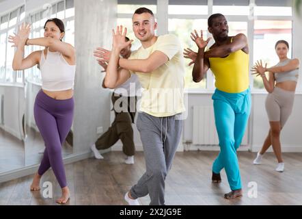 Young instructor leading zumba class for multiethnic group Stock Photo