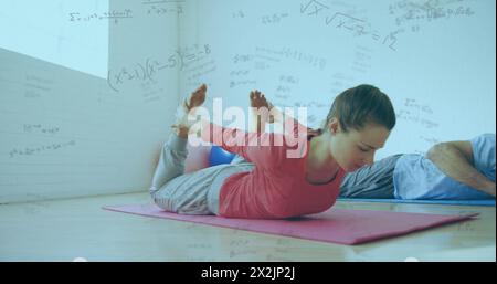 Image of mathematical equations floating over Caucasian couple exercising Stock Photo