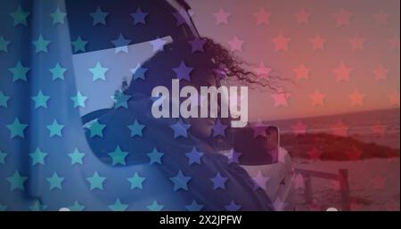 Image of blue and red stars over biracial woman sitting in car Stock Photo