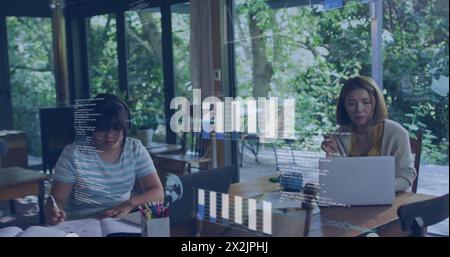 Image of data over asian mother and daughter doing homework and using laptop at home Stock Photo