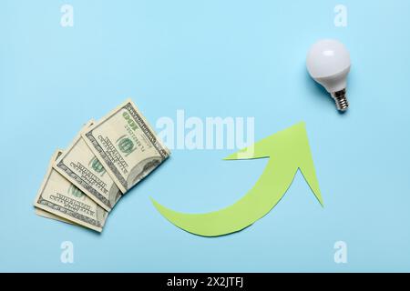 Arrow with dollar banknotes and light bulb on blue background. Price rise concept Stock Photo