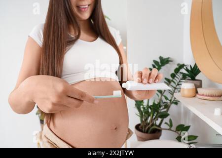 Young pregnant woman with tooth brush and paste in bathroom Stock Photo