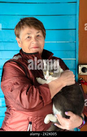 Old Russian woman holding her cat and smiling Stock Photo
