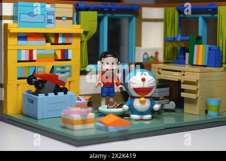 Japanese toy figures (Nobita and Doraemon) standing among the items in his room Stock Photo