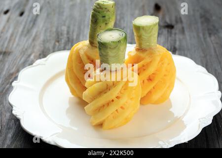 Close Up Whole Ripe Small  Pineapple Peeled on White Plate Stock Photo