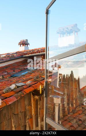 Chimneys and its reflection on glass. Candelario, Salamanca province, Castilla Leon, Spain. Stock Photo