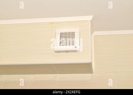 Ventilation system, a box lined with tiles and a fan mounted on the box. Bathroom. Stock Photo