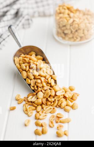 Salted roasted peanuts in scoop on a kitchen table Stock Photo