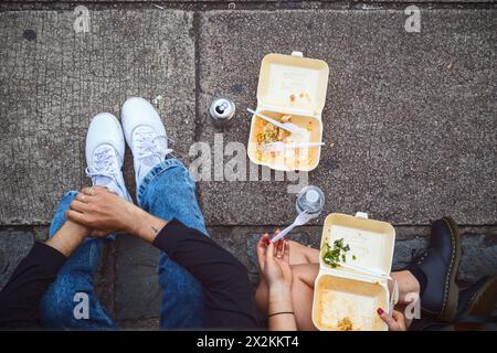 Concept, top view of two tourists eating takeaway on street at Camden market in London Stock Photo