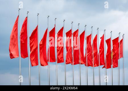 Row of red flags on blue sky background in Vietnam. Vietnamese flags fluttering in the park. Nobody, travel photo Stock Photo