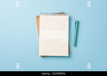 Top view of notebook and fountain pen on blue background Stock Photo