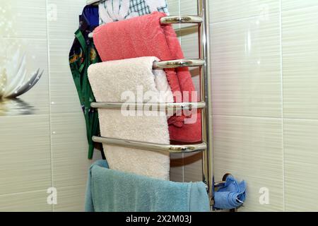 There are towels hanging on the dryer pipes in the bathroom. Stock Photo