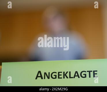 23 April 2024, Thuringia, Suhl: A 'Defendant' sign stands in front of the defendant before the trial at Suhl district court following the fatal accident on the bobsleigh track in Oberhof. A woman who was allegedly working as a volunteer track assistant for a regional sports club on the day of the accident must stand trial for involuntary manslaughter at Suhl district court. At the end of February 2023, a guest bob hit a double tube ring in the finish area of the toboggan run. A 45-year-old man and a 41-year-old woman were sitting in the rubber rings filled with air. The man died and the woman Stock Photo