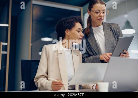 Two female professional executives experts discussing financial accounting papers working together Stock Photo