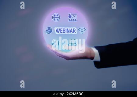 Webinar. Businessman holding virtual icons on color background, closeup Stock Photo