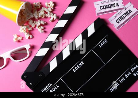 Flat lay composition with clapperboard and popcorn on pink background Stock Photo