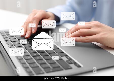Email. Woman using laptop at table, closeup. Letter illustrations over device Stock Photo