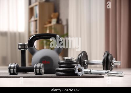 Many different sports equipment on floor indoors Stock Photo