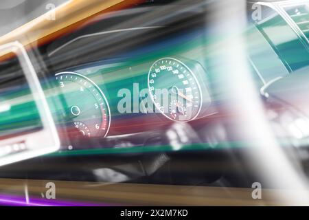 Speedometer and tachometer behind steering wheel in car, motion blur effect Stock Photo