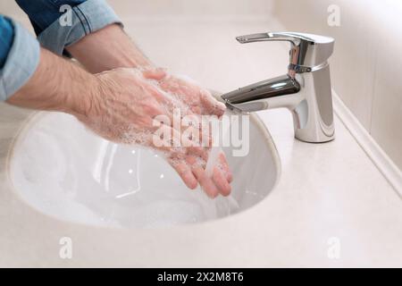 Proper washing and handling hands rubbing palms with soap for coronavirus prevention, hygiene to stop spreading COVID-19. Liquid antibacterial soap Stock Photo