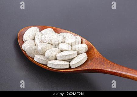White color medicine pills full on blown wooden spoon, healthy diet concept. Stock Photo