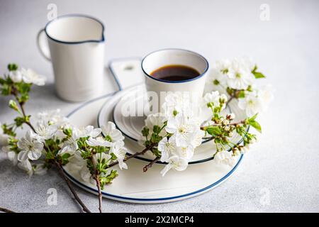 Elegant table setting with white cherry blossoms and a cup of coffee on a serene background Stock Photo