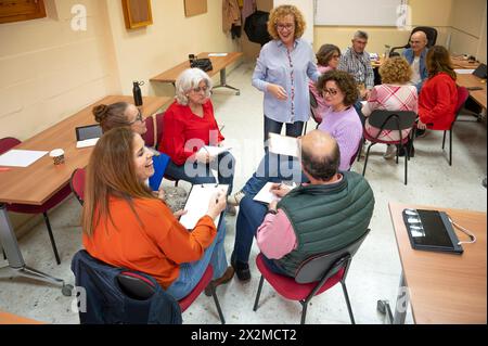 A vibrant senior education class with an enthusiastic teacher and engaged students participating in a group discussion Stock Photo