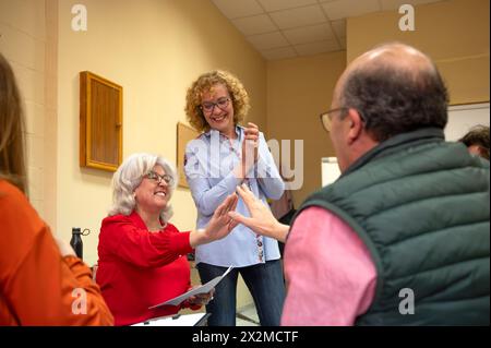 A joyful group of senior students engaging in a class with smiles and a handshaking gesture Stock Photo