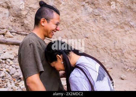 A happy couple sharing a light-hearted moment with genuine smiles in an outdoor setting Stock Photo