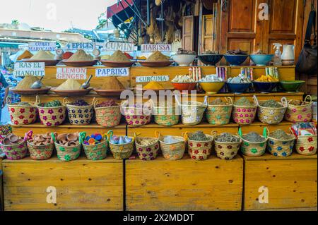 Vibrantly colored spices and herbs displayed in decorative wicker baskets at a traditional Moroccan market, showcasing the culinary culture of Morocco Stock Photo